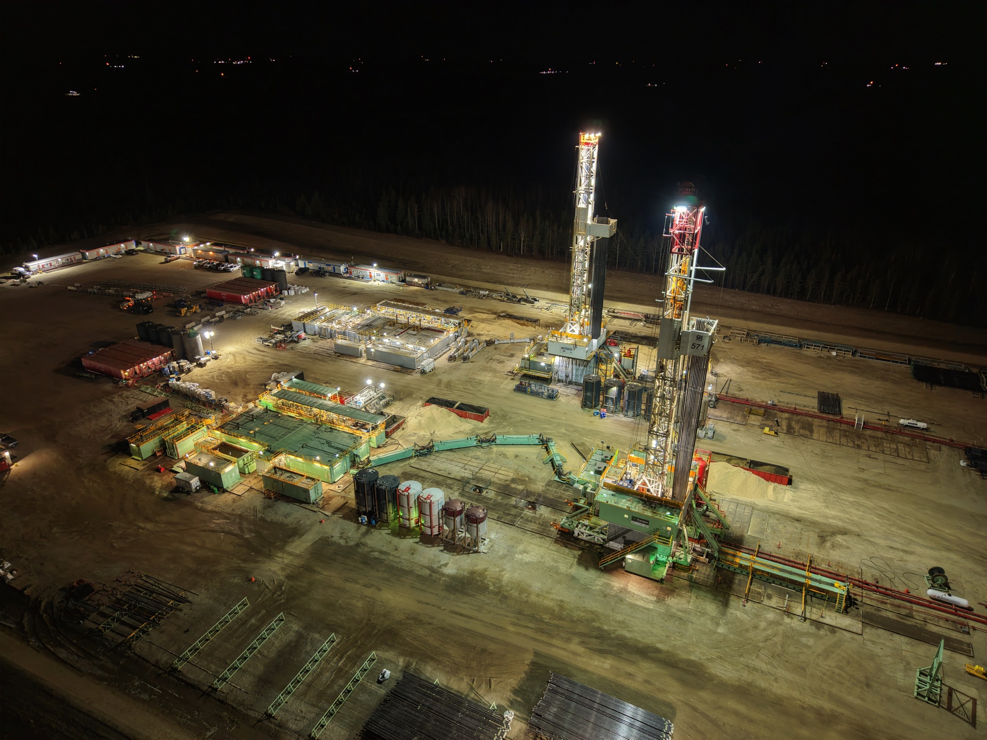 Aerial view of an illuminated drilling site at night